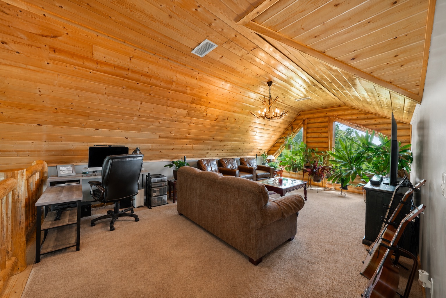 Upper level loft with vaulted wood ceiling and sitting area