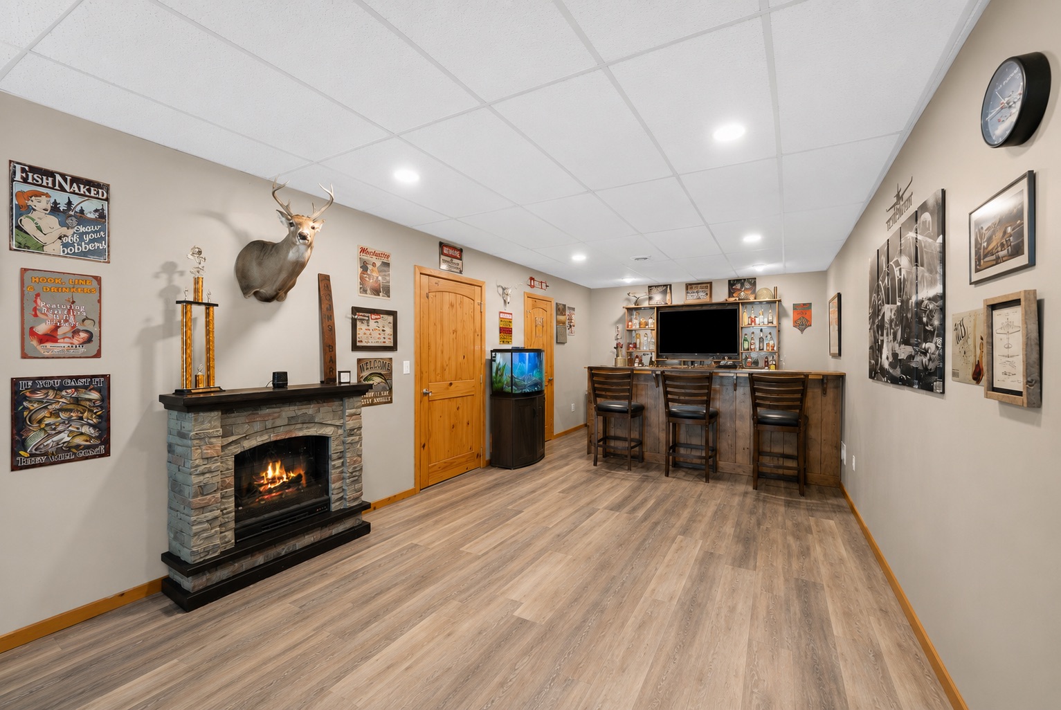Lower level rec room with bar and stone fireplace