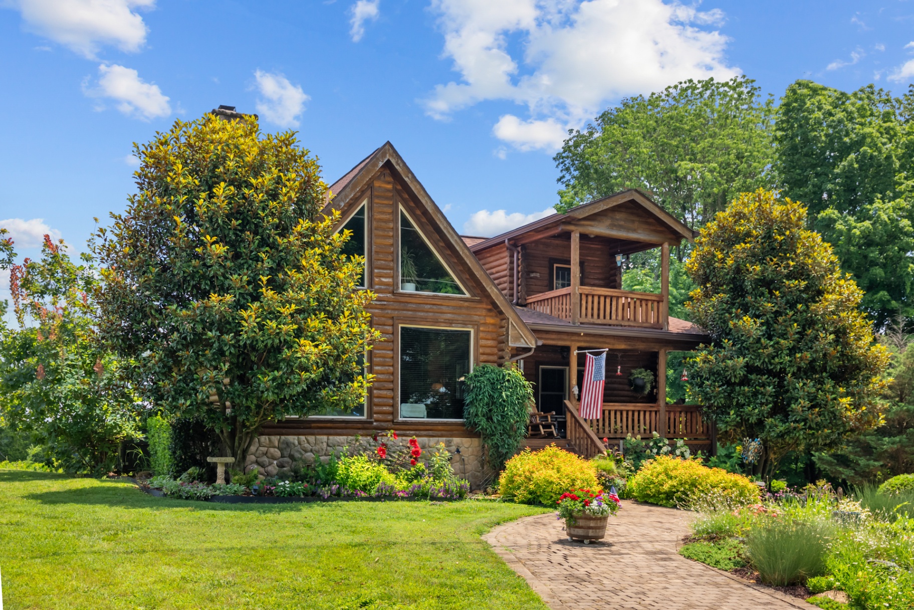 Log home framed by mature trees